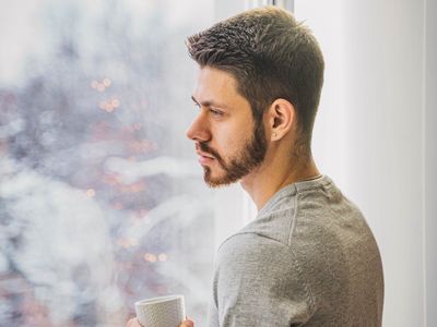 Peaceful scene of a person meditating near a window with soft morning light.