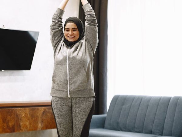 Person moving gracefully from one yoga pose to another in a bright room.